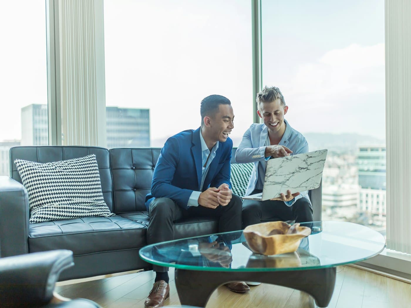 Two people discussing loan options over a laptop in a bright office